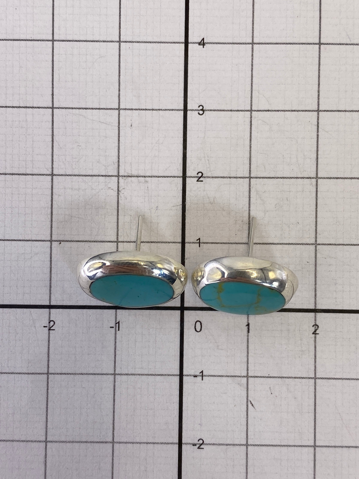 Aretes de turquesa sobre fondo blanco — tamaño real 1.4 cm