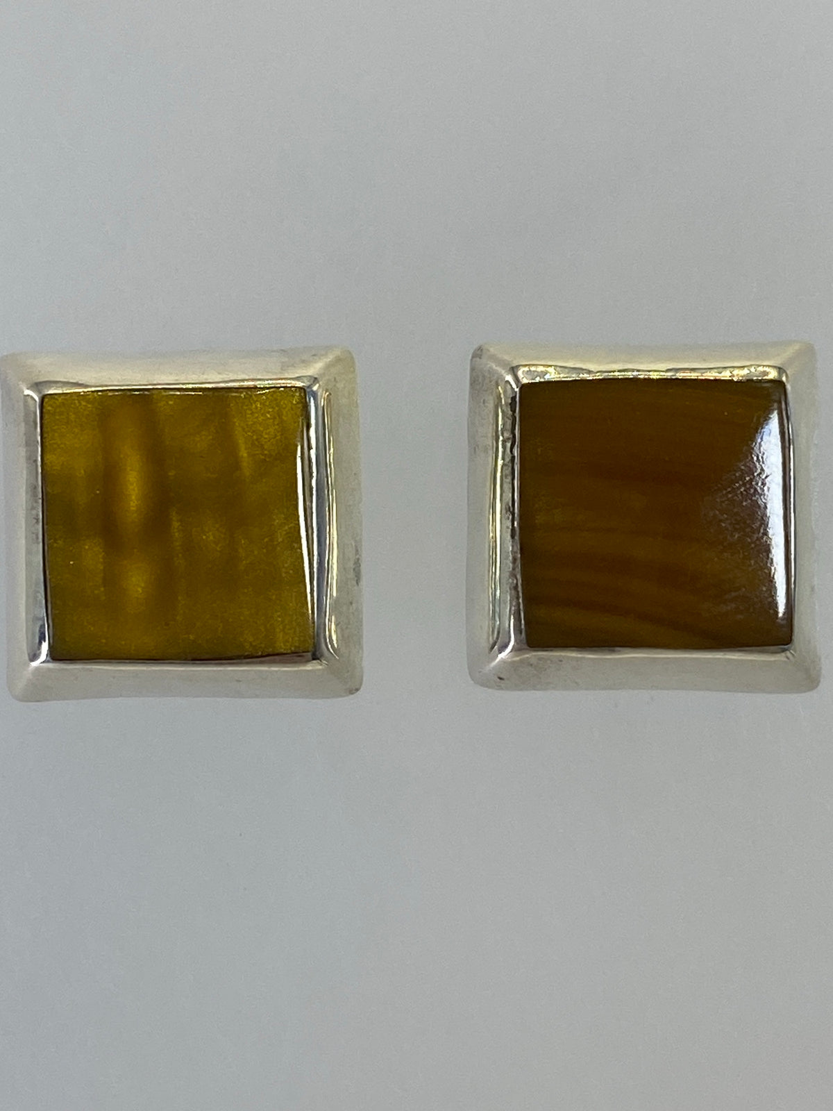 Aretes de frente mostrando los tonos multicolor y el acabado pulido
