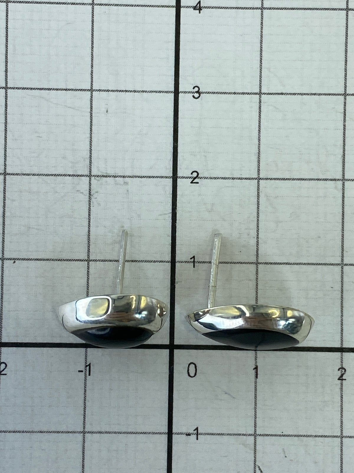 Aretes sobre escala mostrando peso mínimo y sello 925 de autenticidad