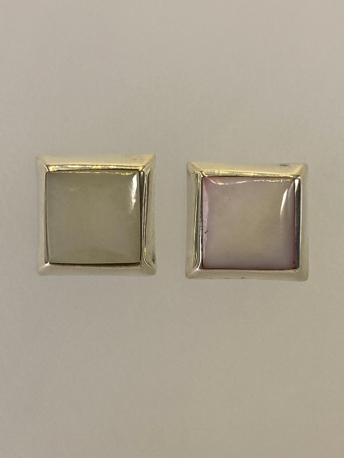 Par de aretes de plata 925 con piedra incrustada, vistos de frente sobre fondo blanco