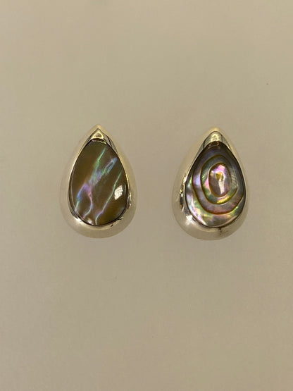 Detalle de los aretes mostrando la incrustación de piedra multicolor con reflejos de color