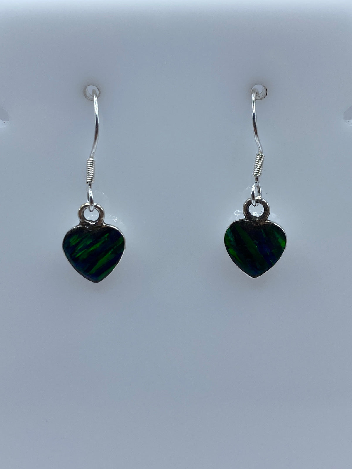 Detalle del engaste a mano del ópalo de fuego verde en plata 925