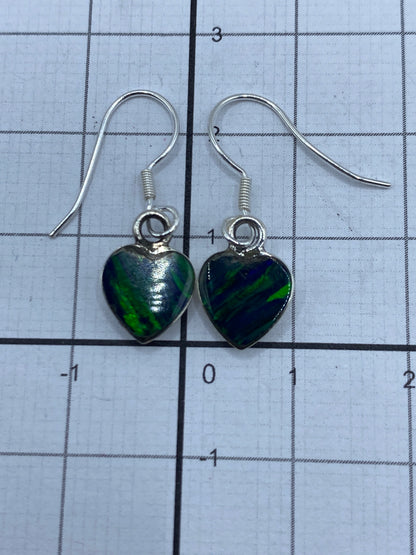 Aretes de plata sobre fondo blanco con medida de referencia (2.3 cm)