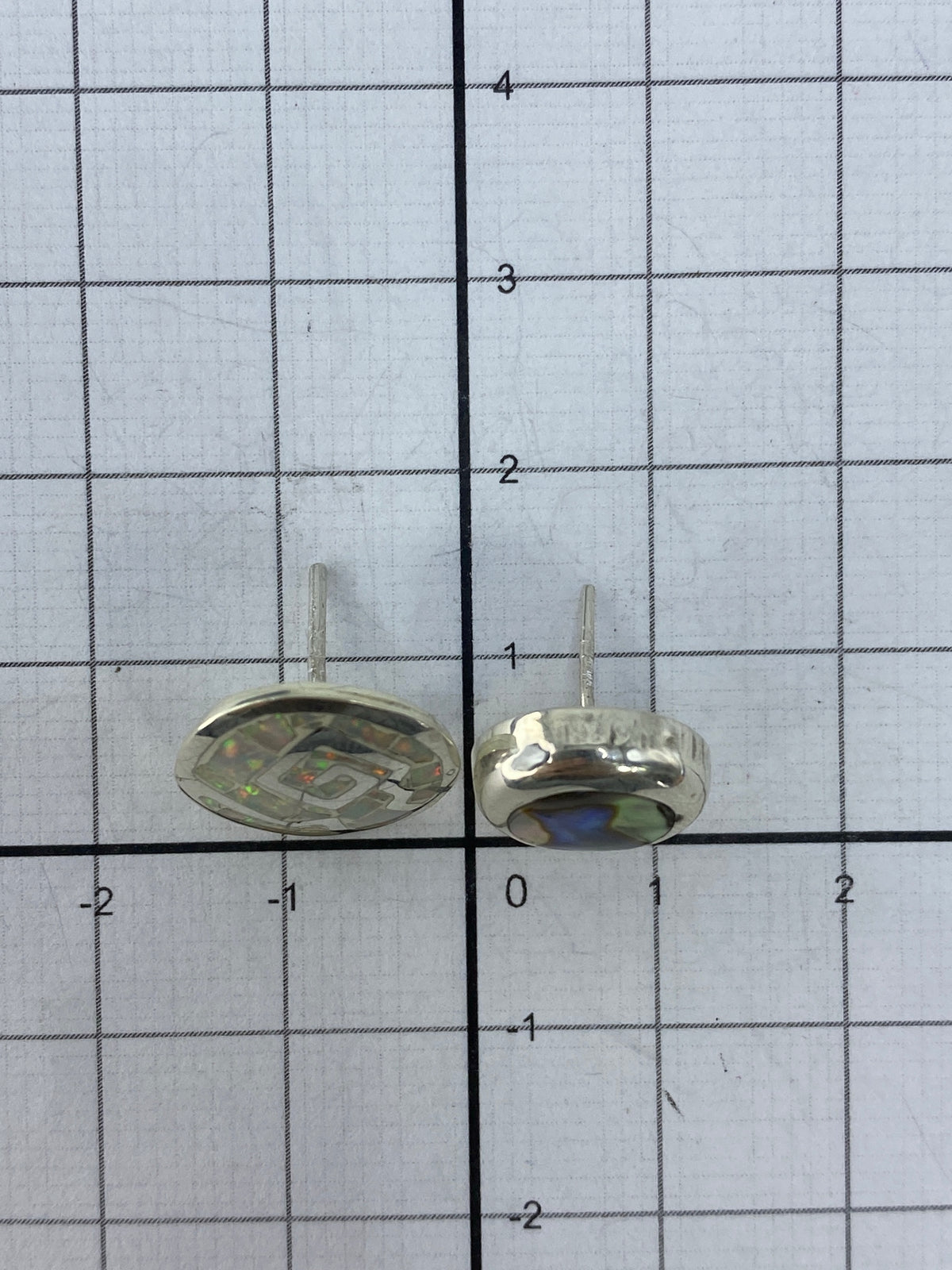 Los aretes sobre regla mostrando el tamaño real de 1.3 cm de largo