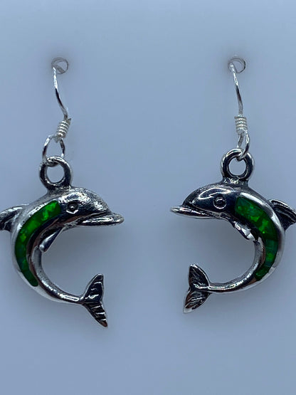 Aretes colgando mostrando el opalo de fuego brillando a la luz