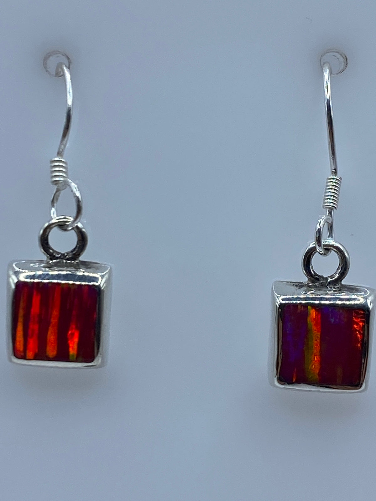 Aretes colgantes sobre fondo blanco mostrando el Quinto 925
