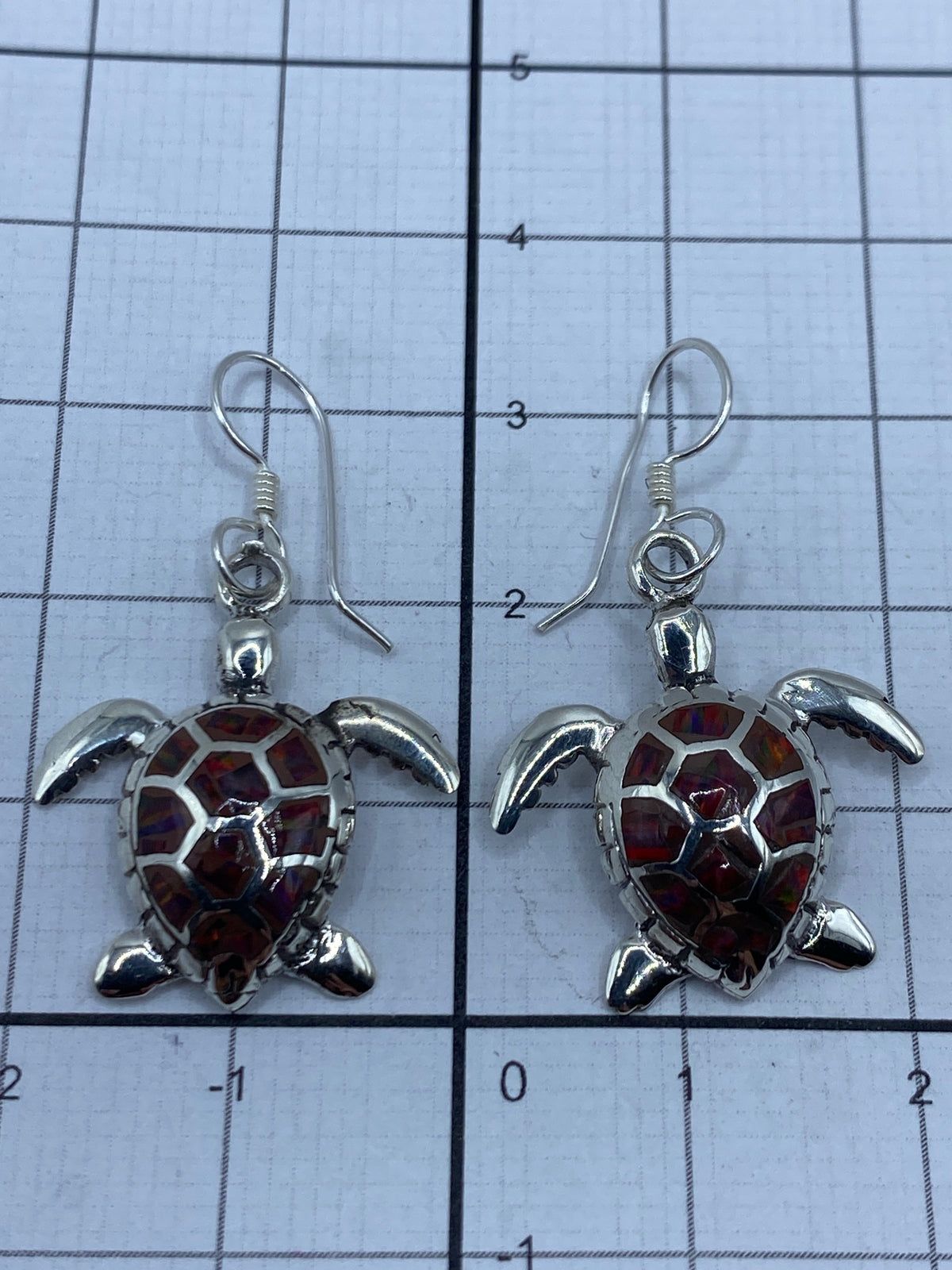 Aretes sobre escala de medición mostrando largo de 3.3 cm