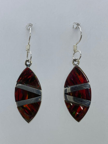 Par de aretes de plata 950 con ópalo de fuego multicolor engastado, colgando sobre fondo blanco