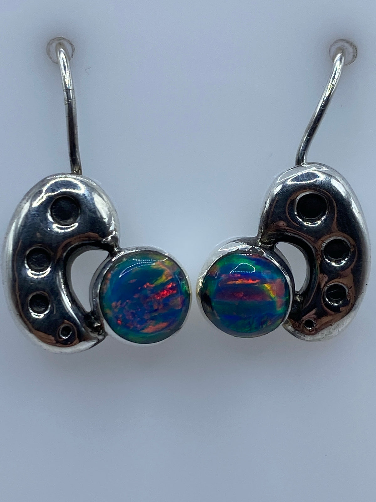 Aretes colocados en una regla mostrando el tamaño de 2.1 cm