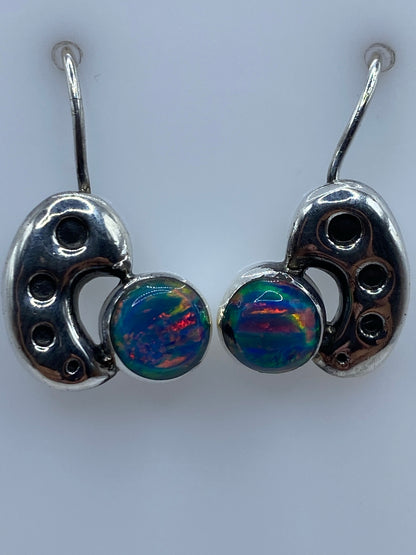 Aretes colocados en una regla mostrando el tamaño de 2.1 cm