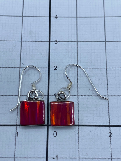 Aretes sobre fondo gris, escala en centímetros mostrando el largo de 2.4 cm