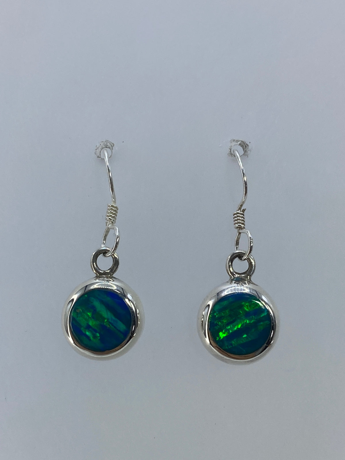Detalle de la piedra ópalo de fuego verde con reflejos internos en cada arete