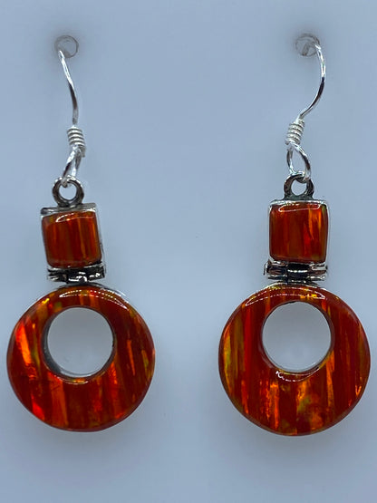 Par de aretes colocados en ganchos de plata, mostrando el color naranja luminoso