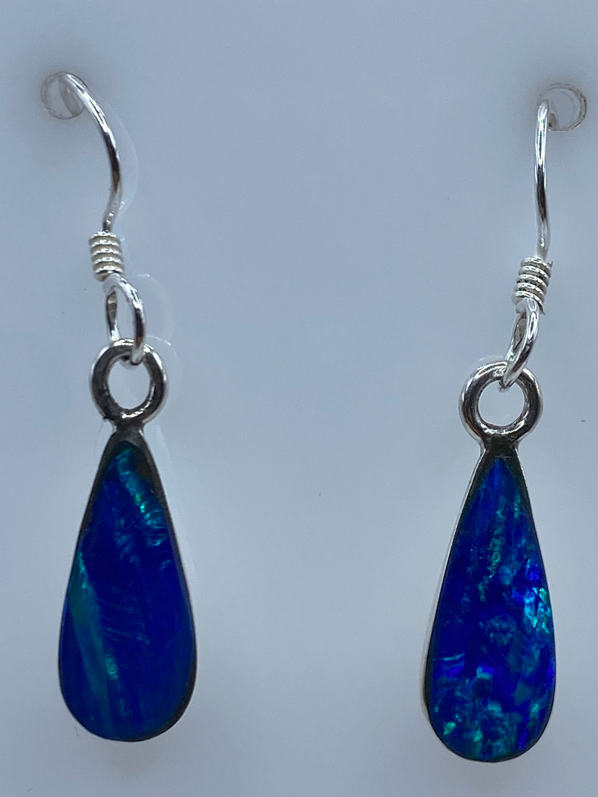 Aretes de ópalo de fuego con gancho de plata en calibrador de medidas