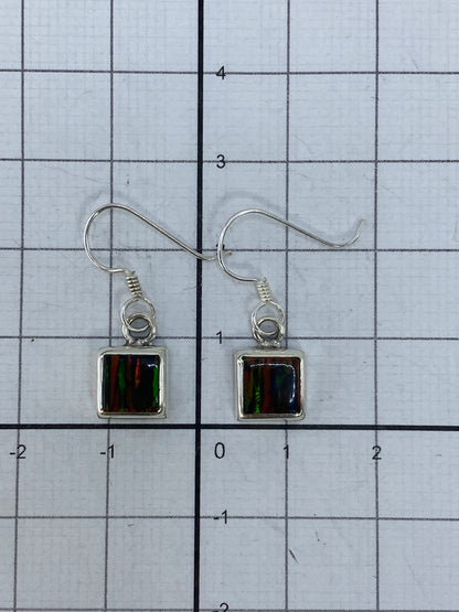 Aretes colgando, mostrando el largo de 2.4 cm y el movimiento de la luz en la piedra