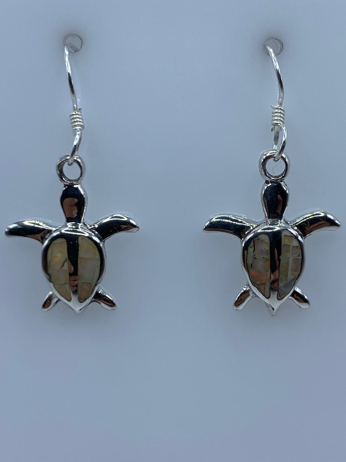 Par de aretes de plata tortuga con ópalo de fuego multicolor, visto de frente