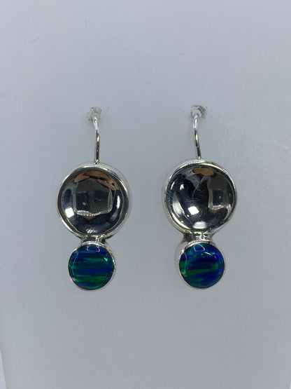 Detalle frontal de ambos aretes mostrando la incrustación de piedra y el brillo del ópalo verde