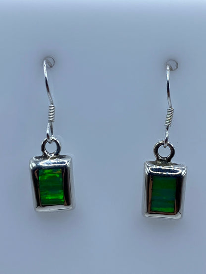 Par de aretes de plata con ópalo de fuego verde, 2.6 cm de largo, sobre fondo neutro