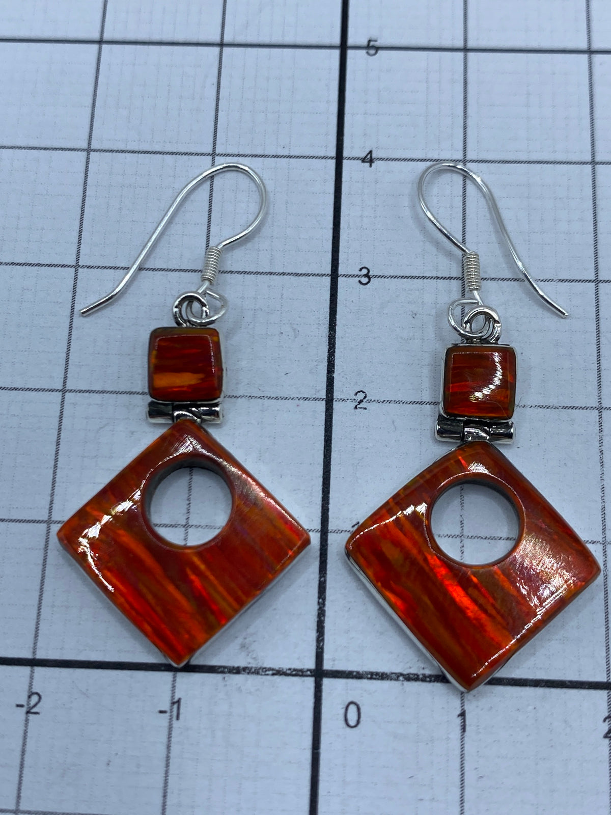 Aretes de plata 950 con ópalo de fuego en estuche azul, mostrando el Quinto