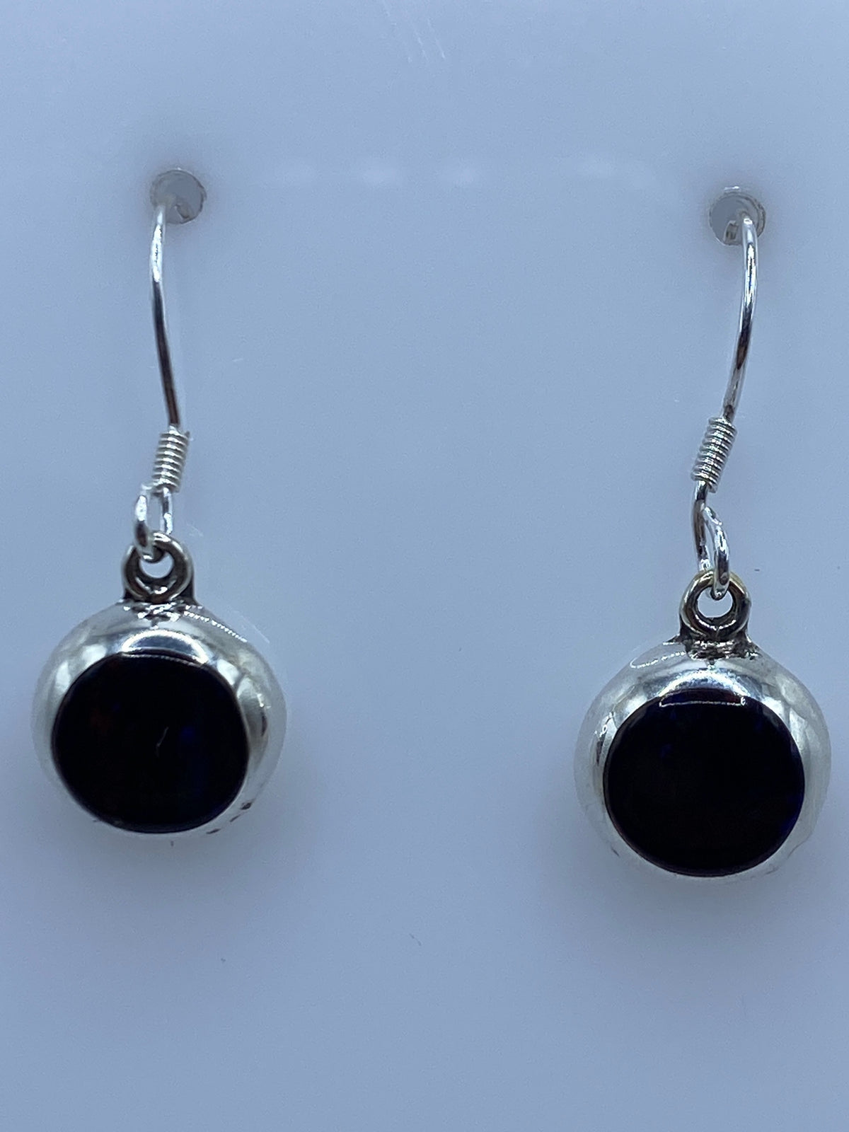 Vista frontal de los aretes de 3.3 cm con brillo multicolor del ópalo