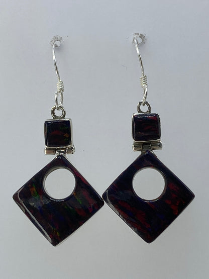 Vista frontal de los aretes: piedras de ópalo con juegos de luz rojo, verde y azul