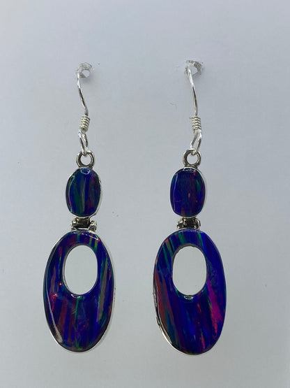 Detalle del ópalo de fuego multicolor con tonos rojo, verde y azul en los aretes
