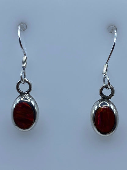 Aretes sobre regla milimetrada mostrando largo de 2.6 cm por pieza