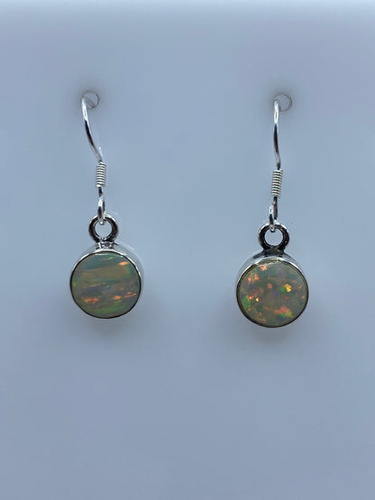 Detalle del ópalo de fuego con reflejos naranja y rojo en los aretes de plata