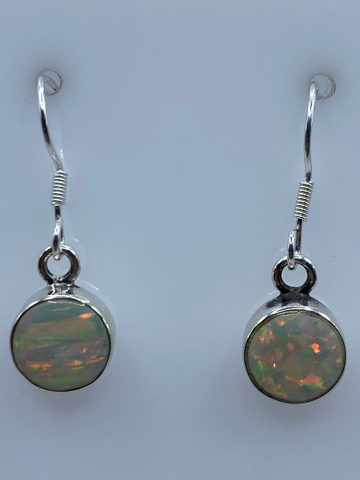 Aretes de plata 950 sobre escala mostrando peso de 1.3 gramos el par