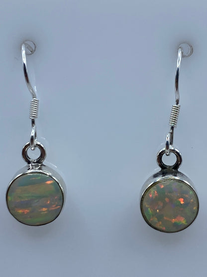 Aretes de plata 950 sobre escala mostrando peso de 1.3 gramos el par