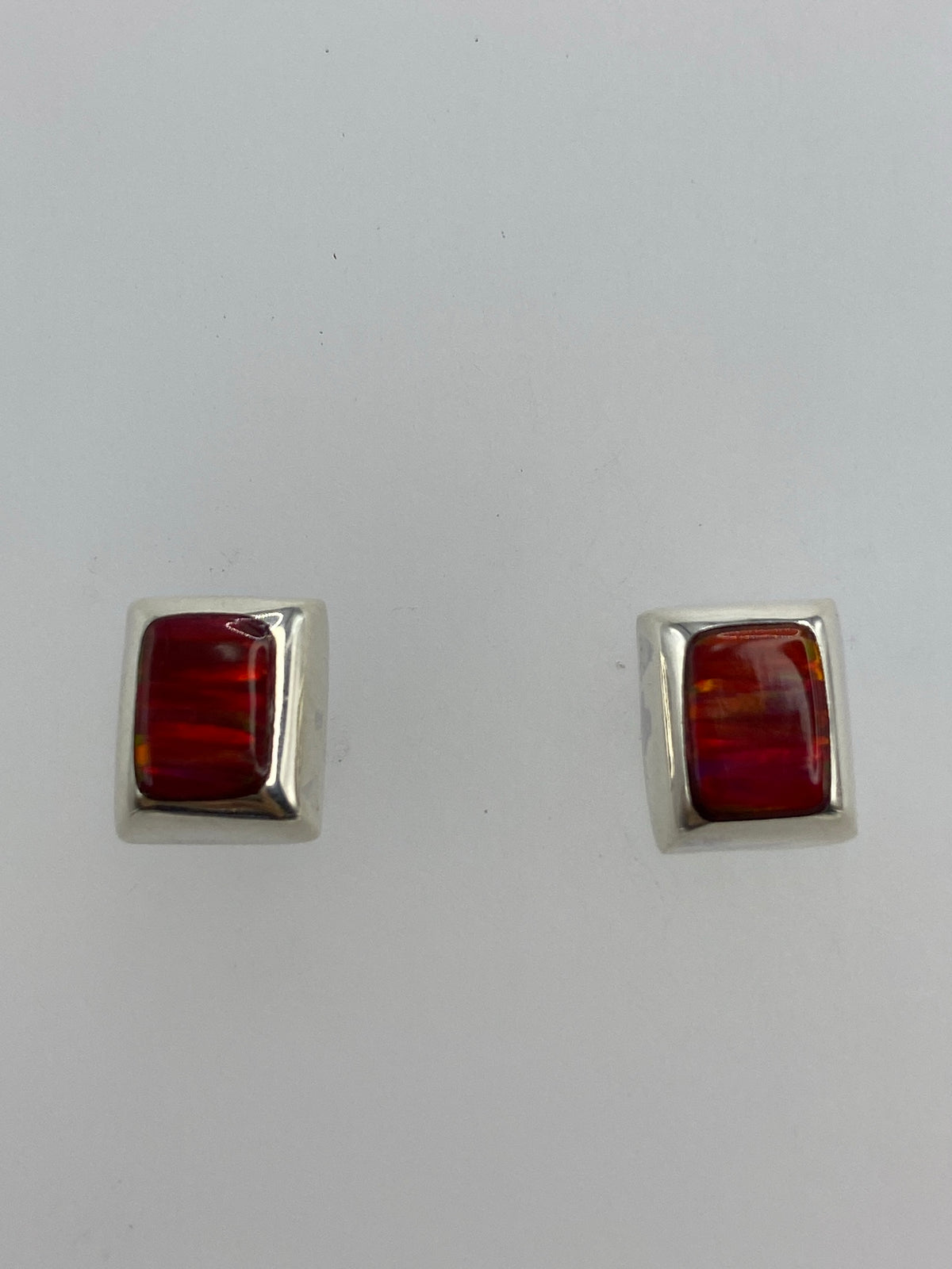 Par de aretes de plata 925 con Ópalo de Fuego rojo engastado, vista frontal sobre fondo blanco
