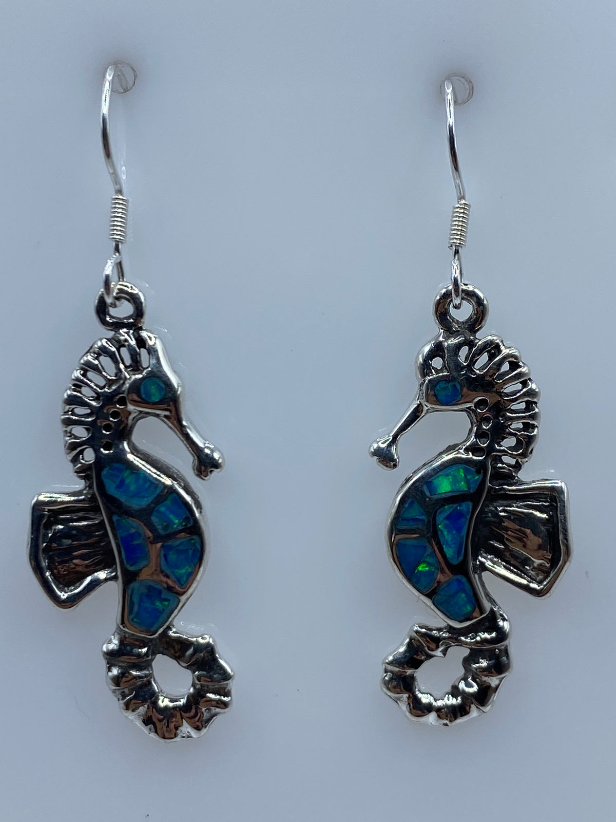 Par de aretes de plata con ópalo de fuego azul incrustado, diseño ondulante en forma de caballito de mar