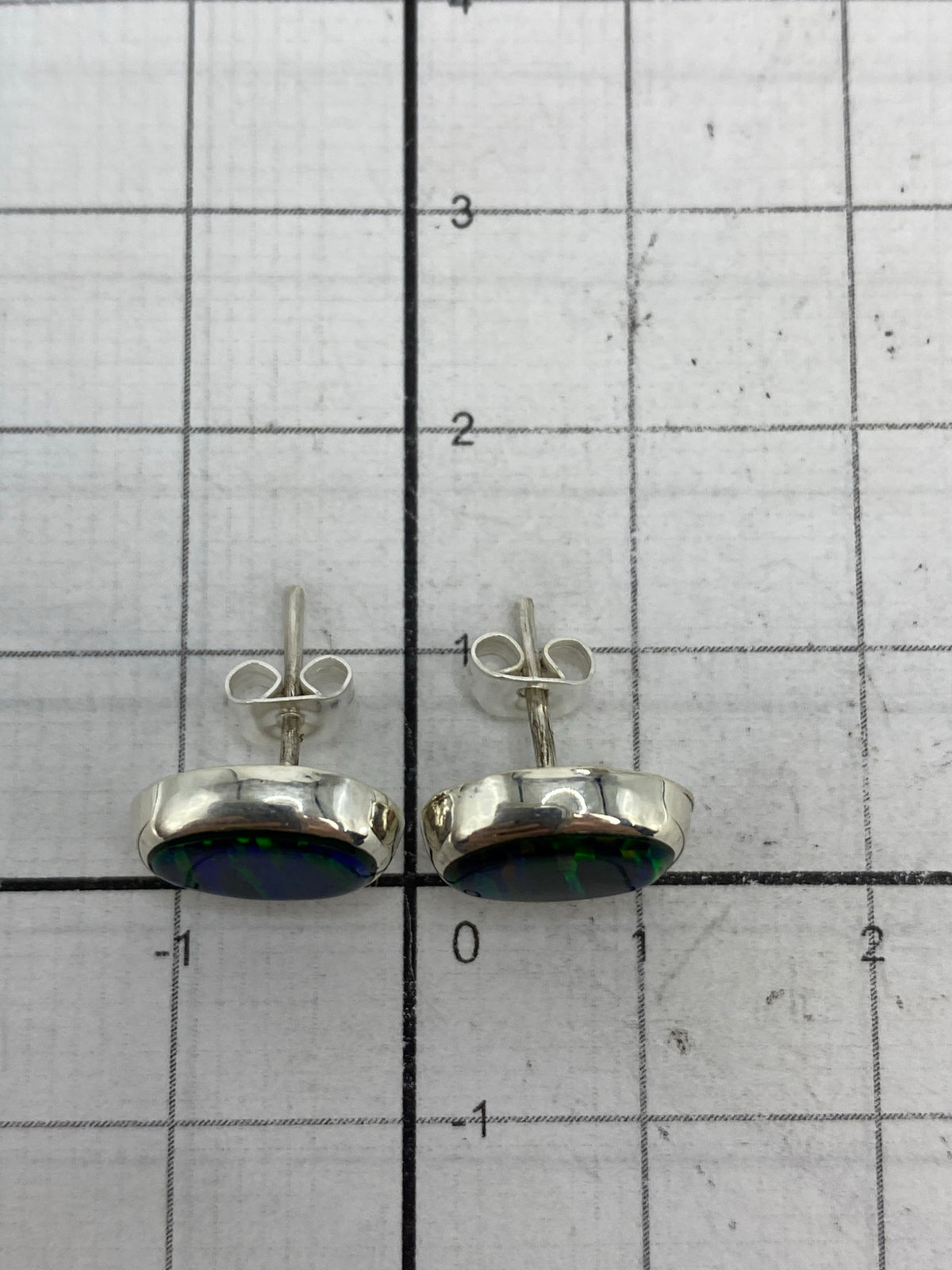 Reverso de los aretes mostrando el Quinto 925 y poste de seguridad