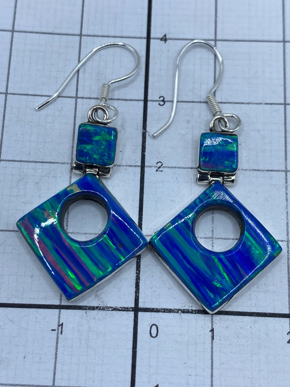 Aretes en la mano mostrando el largo de 3.8 cm y la elegancia del diseño