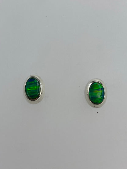 Par de aretes de plata 925 con ópalo de fuego verde engastado, sobre fondo blanco