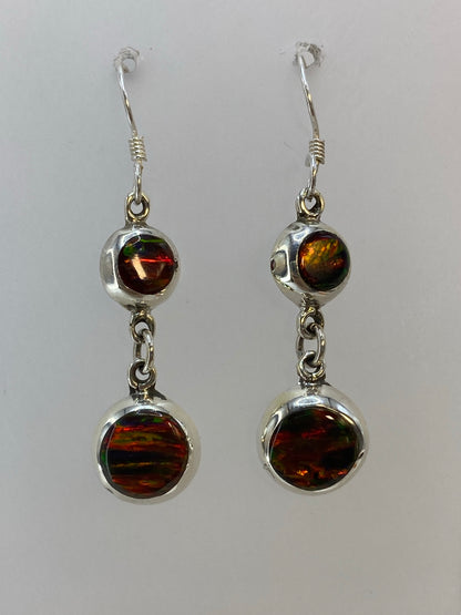 Detalle del ópalo de fuego con destellos rojos, naranjas y amarillos en ambos aretes