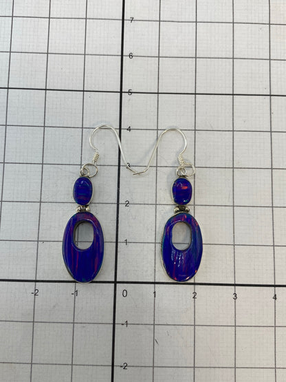 Aretes sobre fondo blanco con el Quinto 950 visible en el ojal