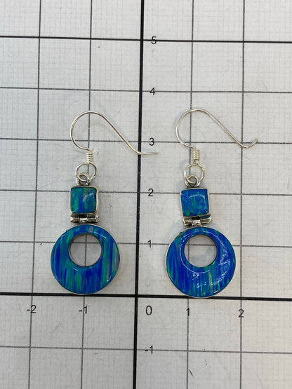 Aretes en la mano mostrando el largo de 3.5 cm y el peso ligero
