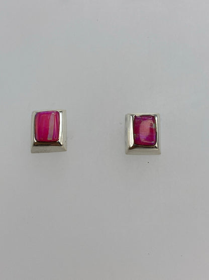 Detalle de un arete mostrando el ópalo de fuego con tonos rosa y ámbar reflectando la luz