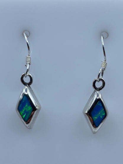 Aretes de plata con ópalo de fuego azul cielo en forma de diamante, par completo en fondo blanco