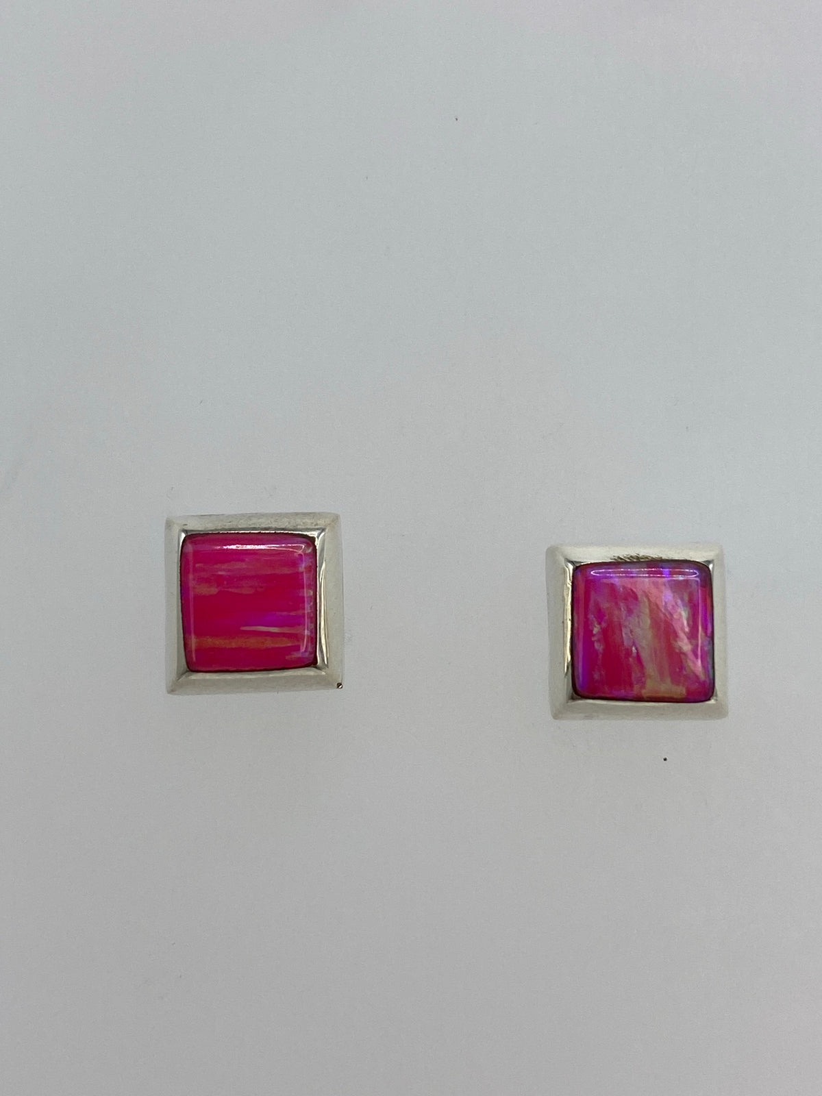 Par de aretes de plata con opalo de fuego rosa, vistos de frente