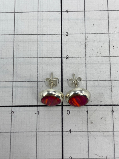 Aretes junto a referencia de tamaño (moneda) mostrando el diminuto tamaño de 1.3 cm