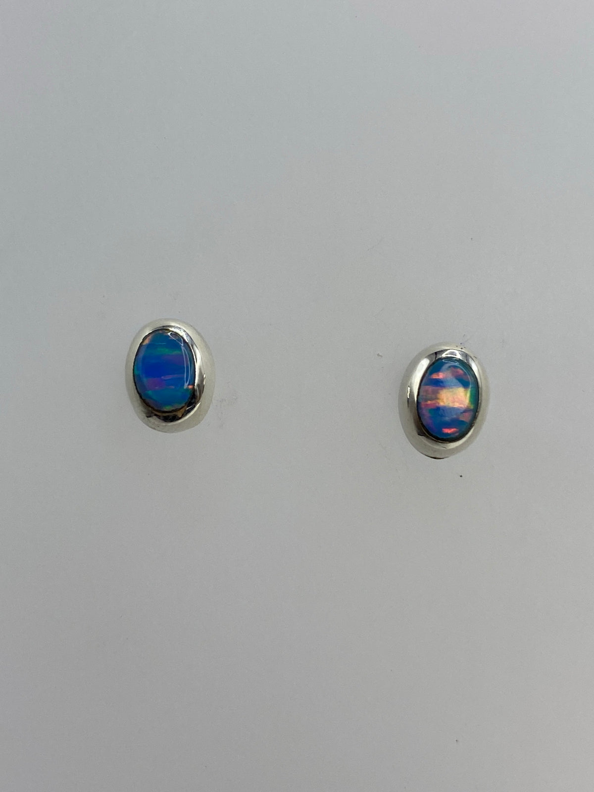 Par de aretes de plata 925 con ópalo de fuego azul cielo en fondo blanco