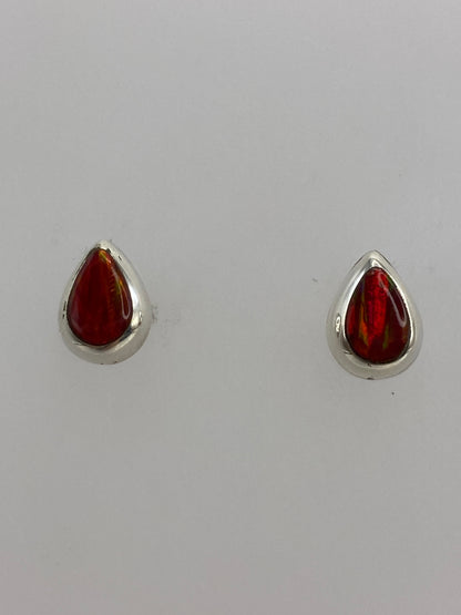 Detalle de un arete mostrando el engaste a mano del ópalo rojo en la plata 925
