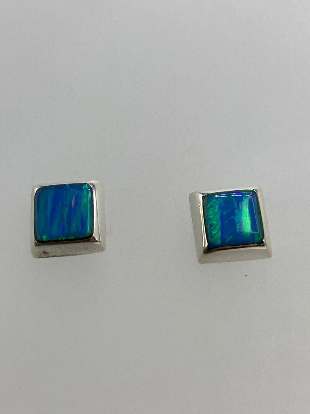 Detalle frontal de uno de los aretes mostrando el engaste de la piedra azul en plata pulida