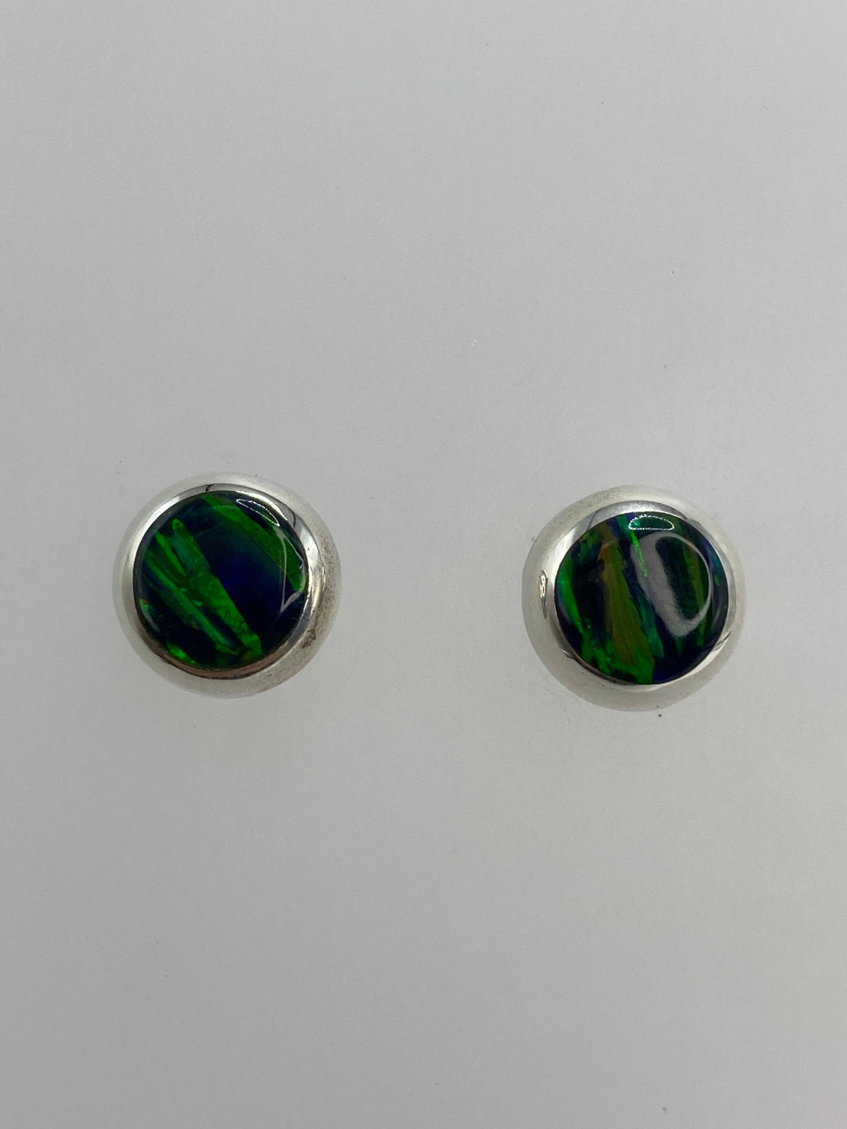 Aretes de plata con ópalo de fuego verde, par completo visto de frente