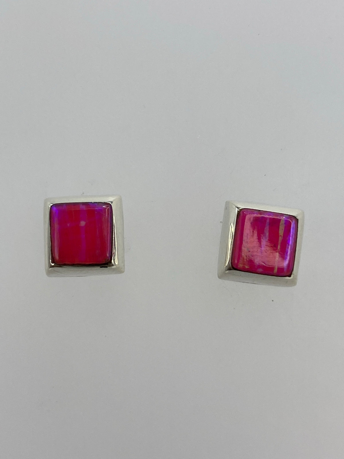 Aretes cuadrados de plata con ópalo de fuego rosa engastado, vistos de frente