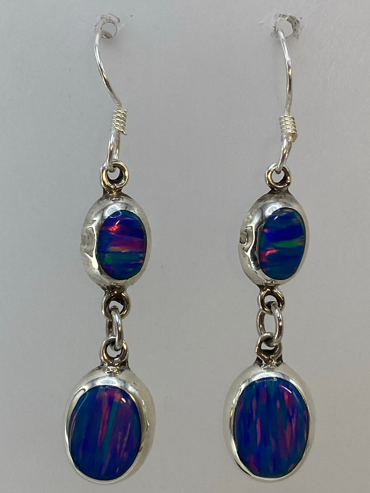 Aretes colgando, mostrando los reflejos de fuego del ópalo