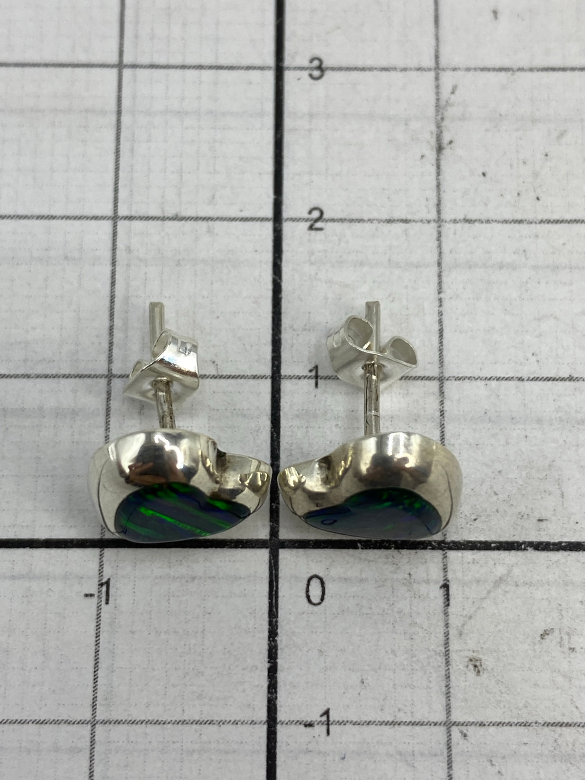 Aretes sobre fondo neutro mostrando el Quinto 925 en la plata