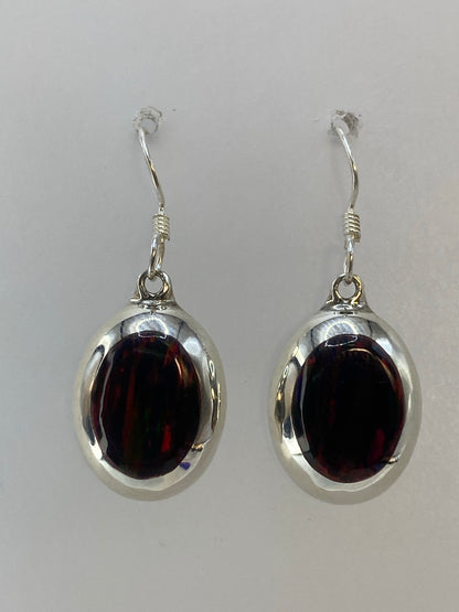 Par de aretes de plata 925 con ópalo de fuego multicolor, colgando sobre fondo blanco